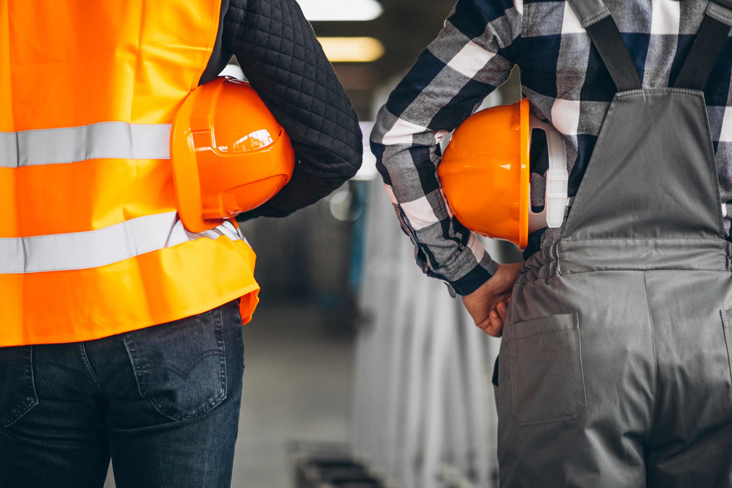 Dos trabajadores de logistica conn cascos mano a mano