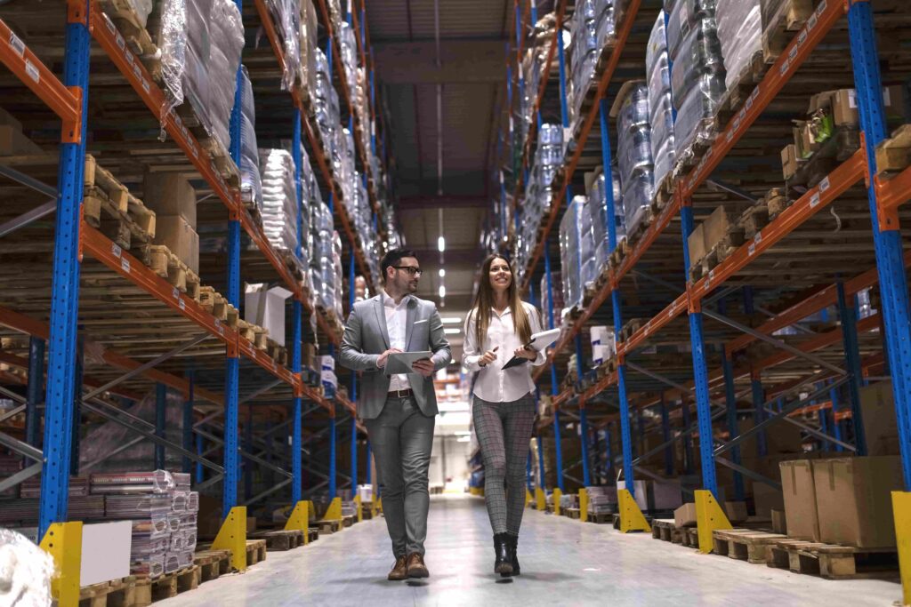 A man and a women working on logistics and distribution in a warehouse